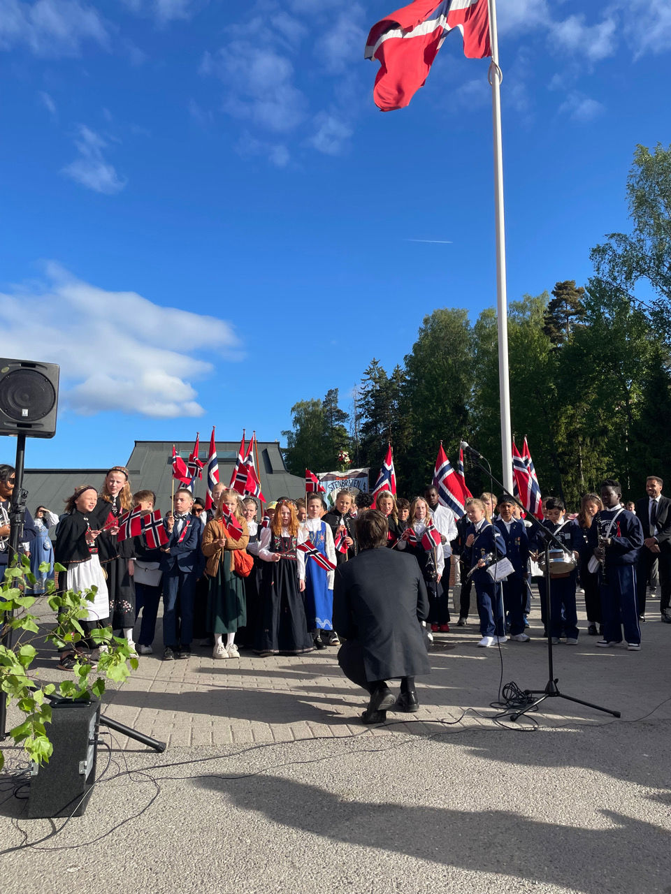 en gruppe mennesker som står utenfor med flagg i ryggen