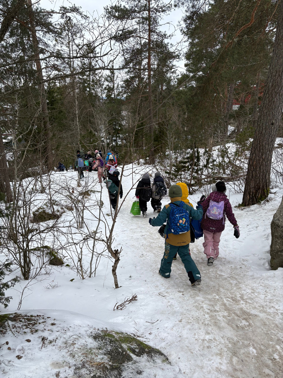 en gruppe mennesker som går i snøen