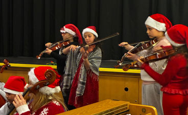En gruppe mennesker i nissehatter som spiller instrumenter