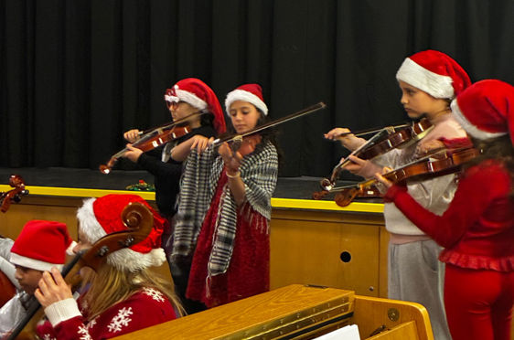 En gruppe mennesker i nissehatter som spiller instrumenter