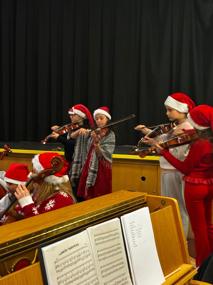 En gruppe mennesker i nissehatter som spiller instrumenter