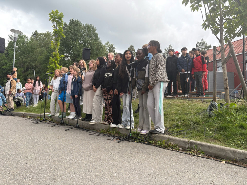 en gruppe mennesker som står på et fortau
