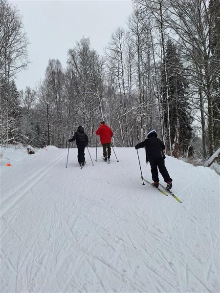 En gruppe mennesker som står på ski ned en skråning