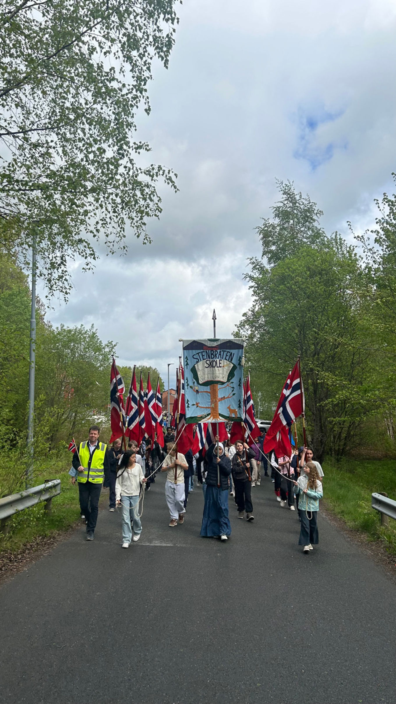 Foto: Marit Hauge Mansaray en gruppe mennesker som går på en vei med flagg