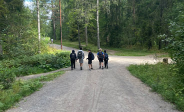 En gruppe mennesker som går på en grusvei i skogen