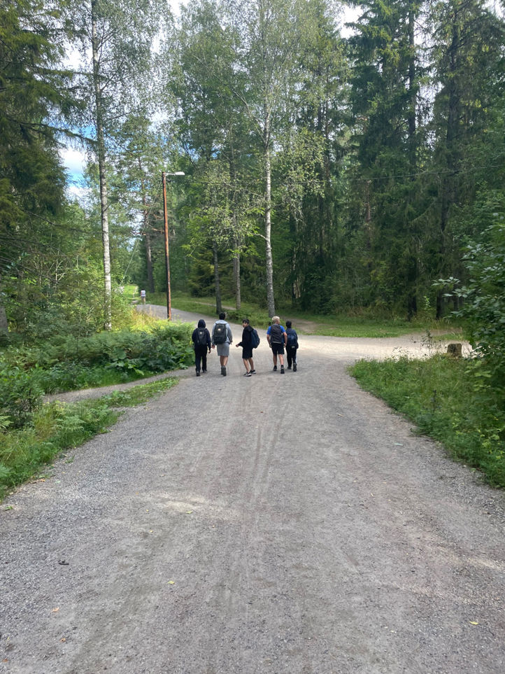 En gruppe mennesker som går på en grusvei i skogen