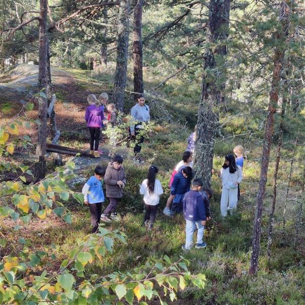 En gruppe mennesker som går gjennom en skog