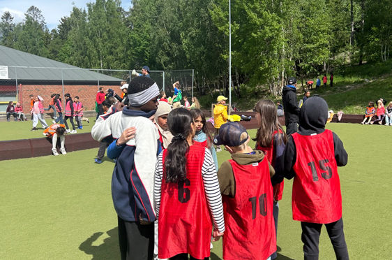 en gruppe mennesker som står på en gressbane