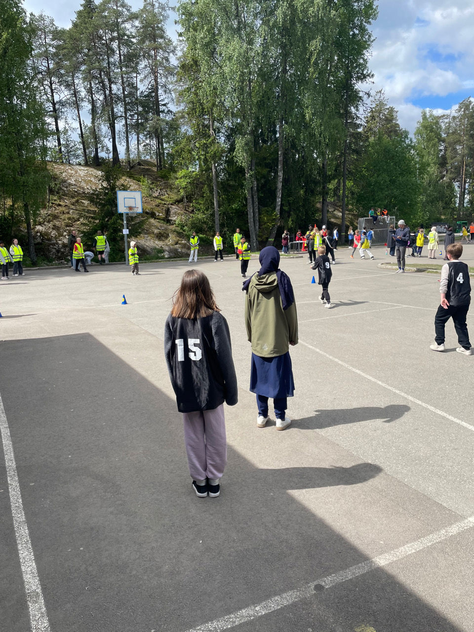 en gruppe mennesker som går på en gate med trær i bakgrunnen