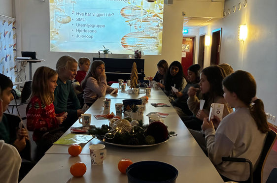 en gruppe mennesker som sitter ved et bord med mat og drikke