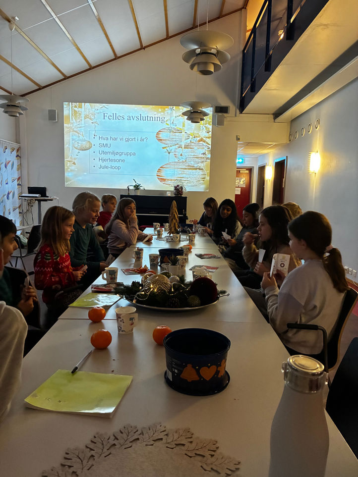 en gruppe mennesker som sitter ved et bord med mat og drikke